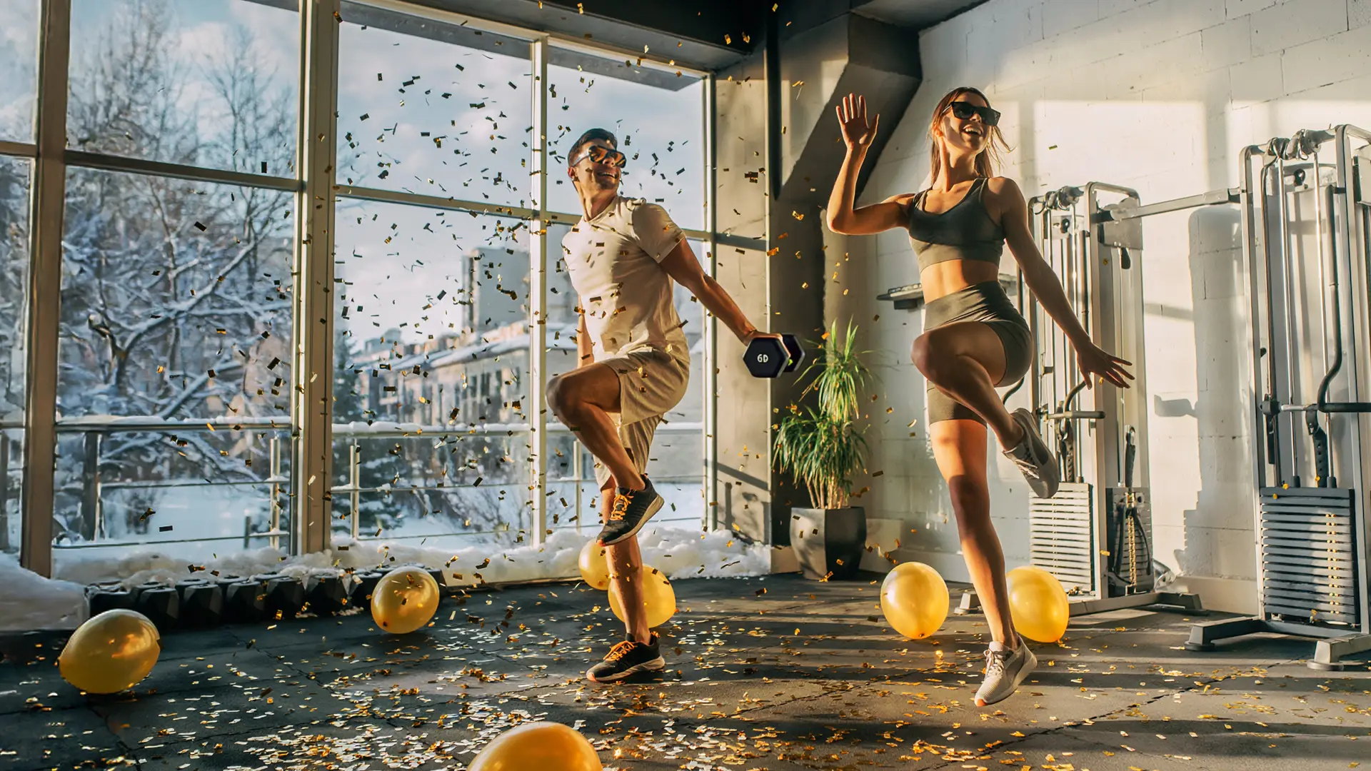 F4U - Paar trainiert zum Jahreswechsel im Fitnessclub mit Sonnenbrille und Ballons