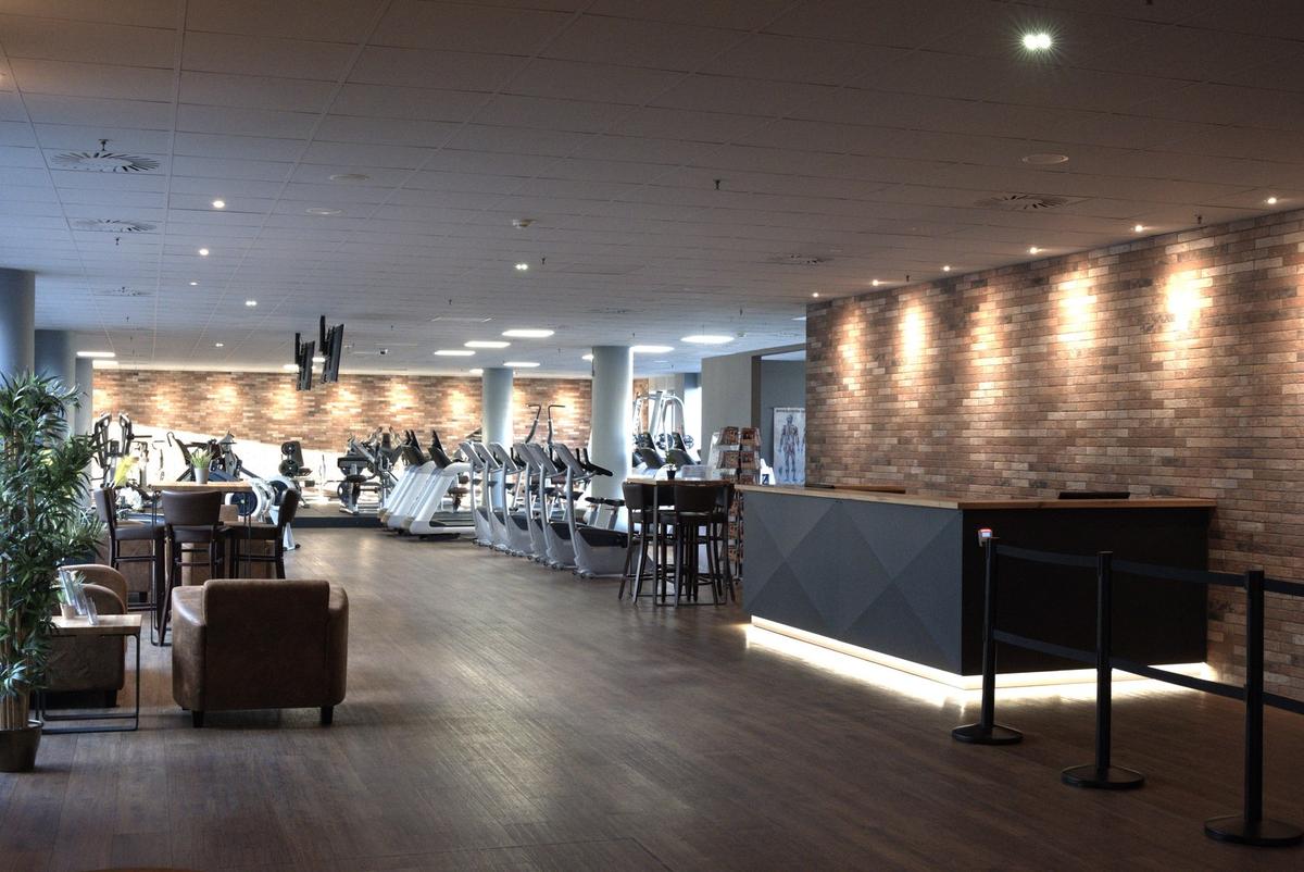 Lounge mit Ledersesseln und Stehtisch vor dem Empfangstresen im F4U Wiesbaden