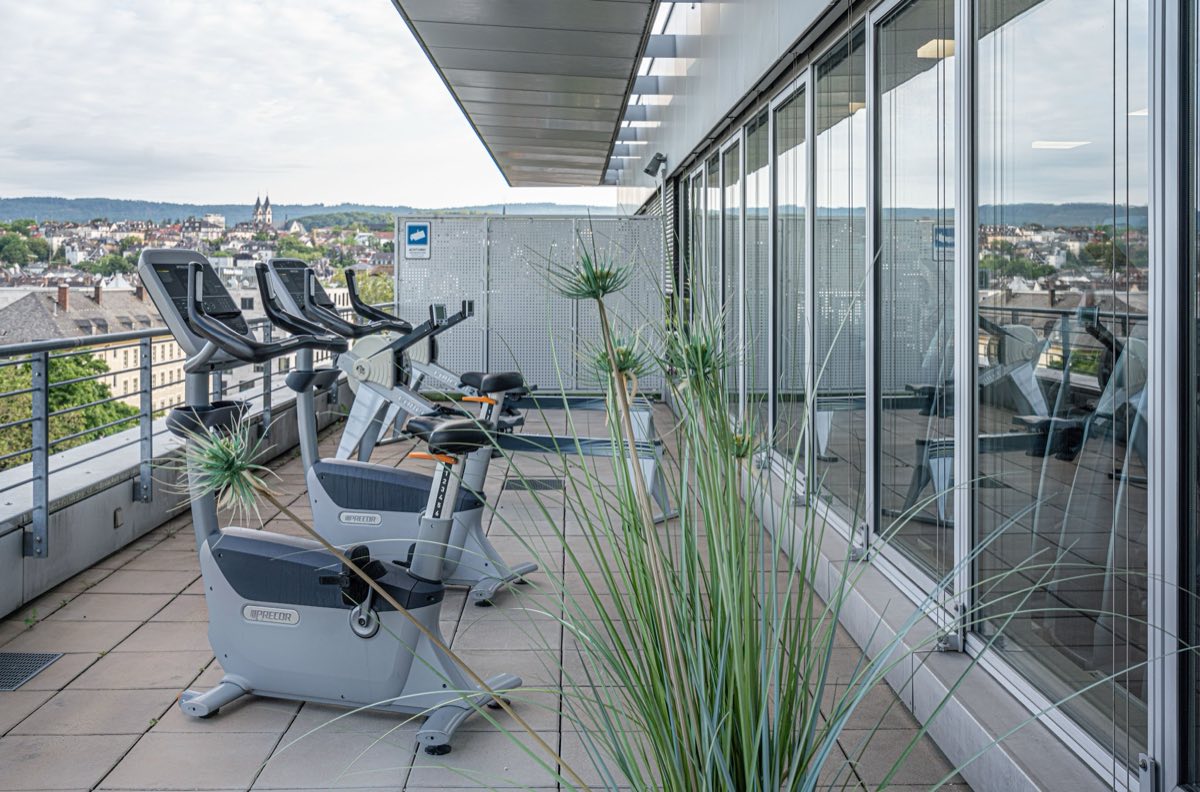 Ergometer und Rudergerät auf der Panoramaterrasse des F4U Wiesbaden mit Blick über die Dächer der Stadt