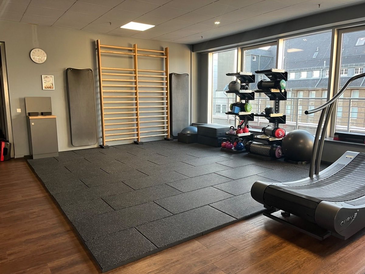 Funktionsfläche im F4U Wiesbaden mit Sprossenwand, Matten, Kettlebells, Medizinbällen und einem Curve-Laufband an der Fensterfront